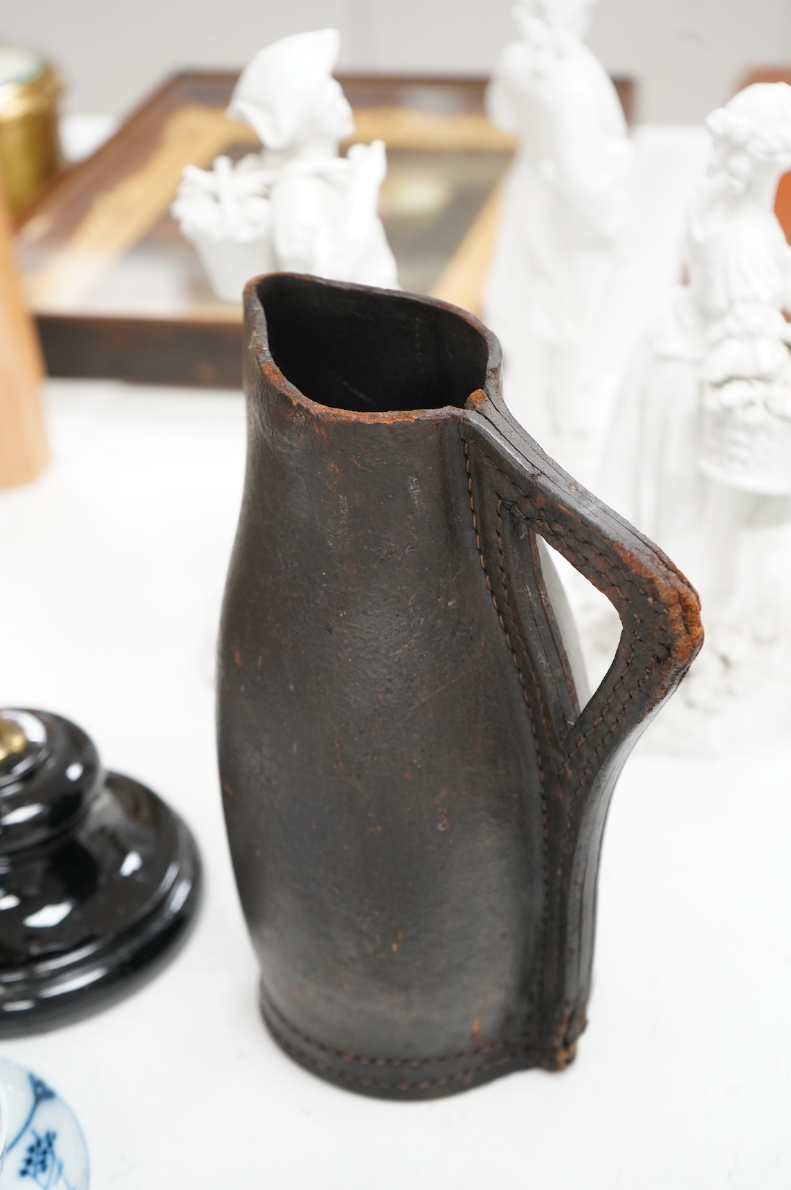 An adjustable wig stand, an oval copper box and a leather black jack jug, 24cm high.